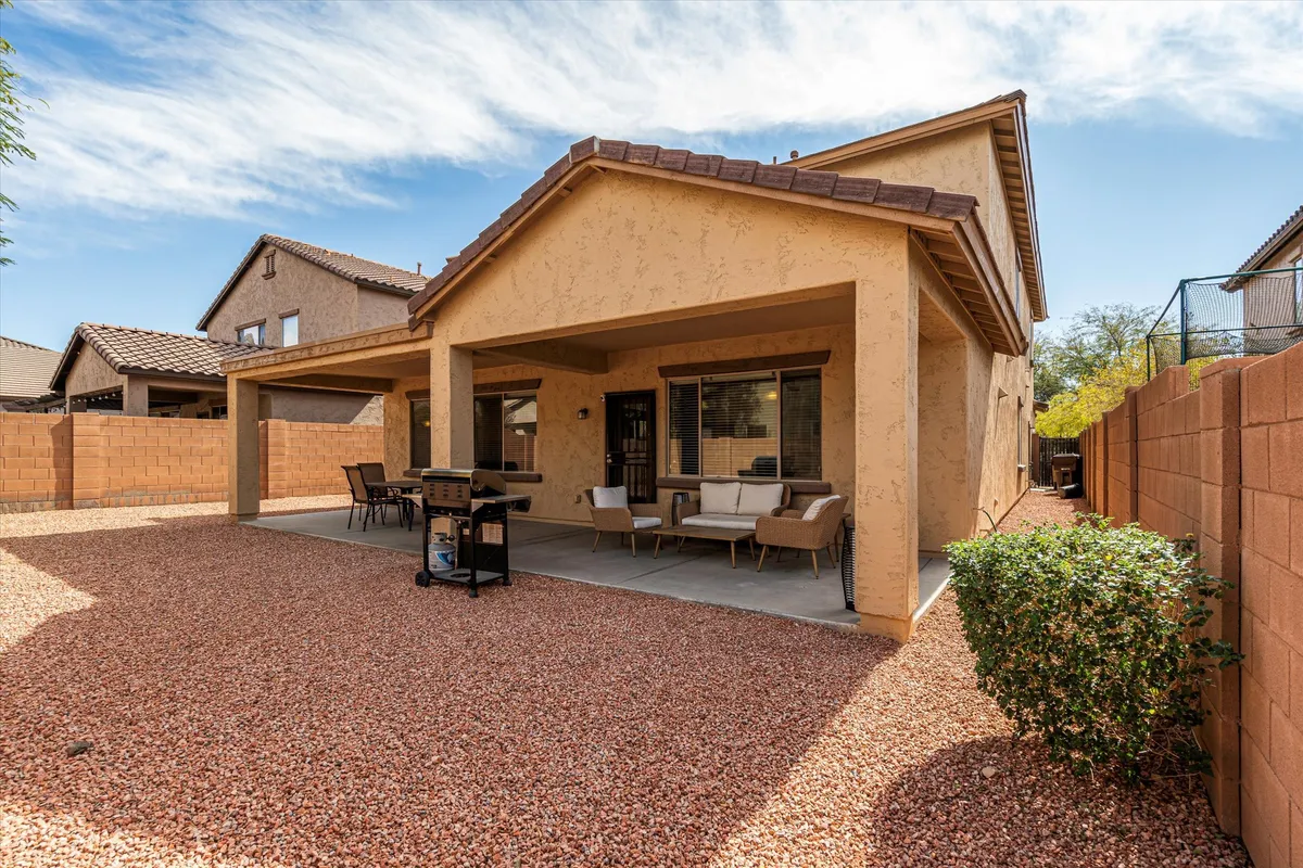 A spacious covered patio and outdoor seating area with a grill, inviting guests to gather for relaxed barbecues and evening conversations under the stars. The setting is casual and welcoming, ideal for group retreats.